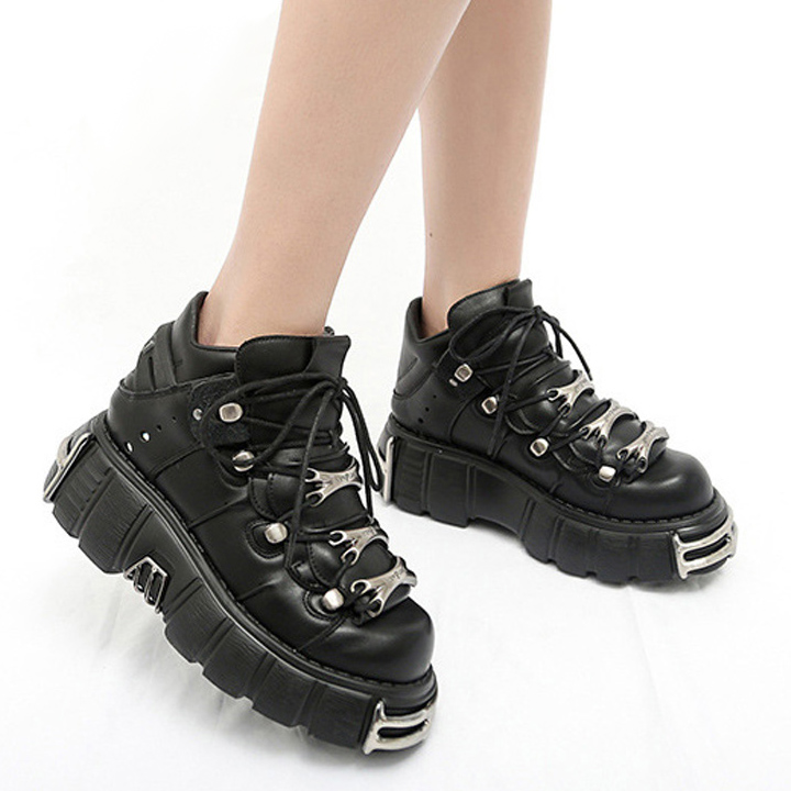Chaussures gothiques plateformes noires en cuir avec semelle épaisse et détails métalliques argentés, vue latérale sur pied