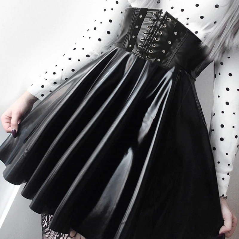 Jupe corset gothique en cuir noir brillant avec laçage avant, portée avec un haut blanc à pois noirs