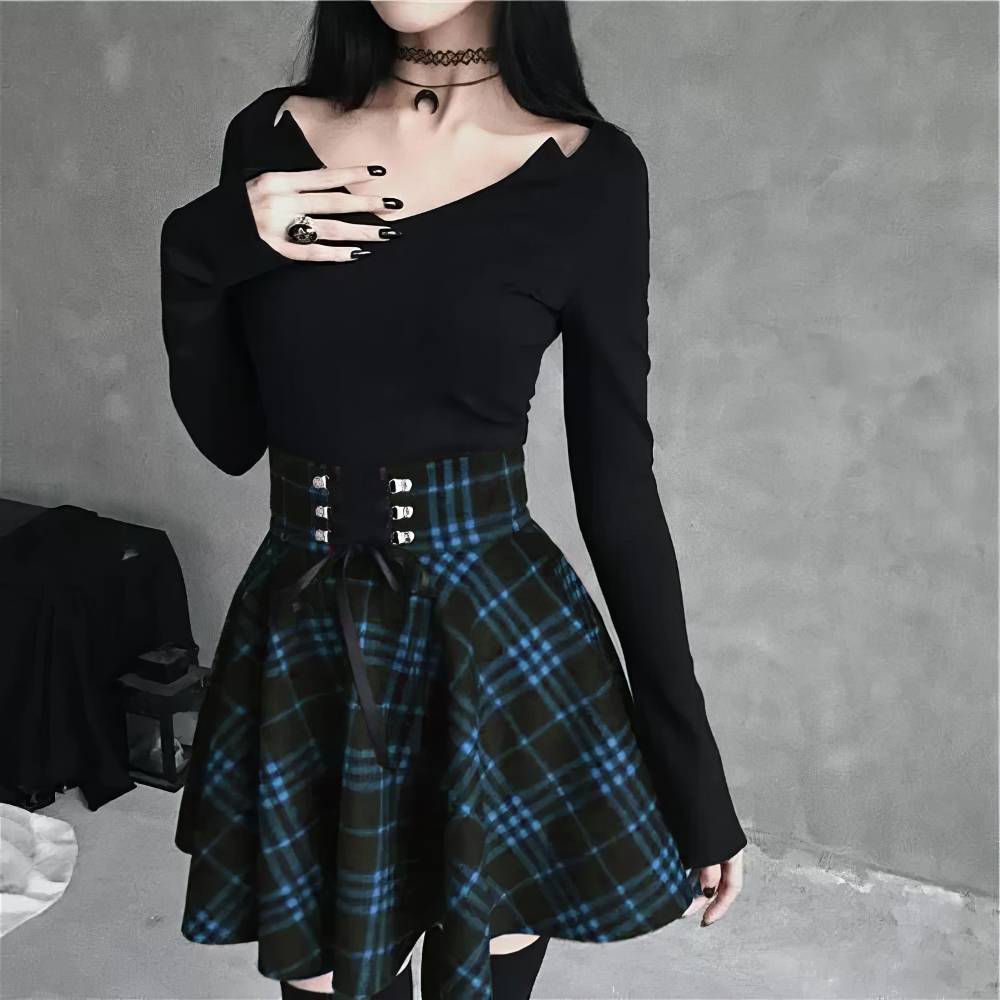 Jupe écossaise gothique Lunaria à motif tartan bleu et noir avec ceinture à boucles métalliques portée avec un haut noir à manches longues