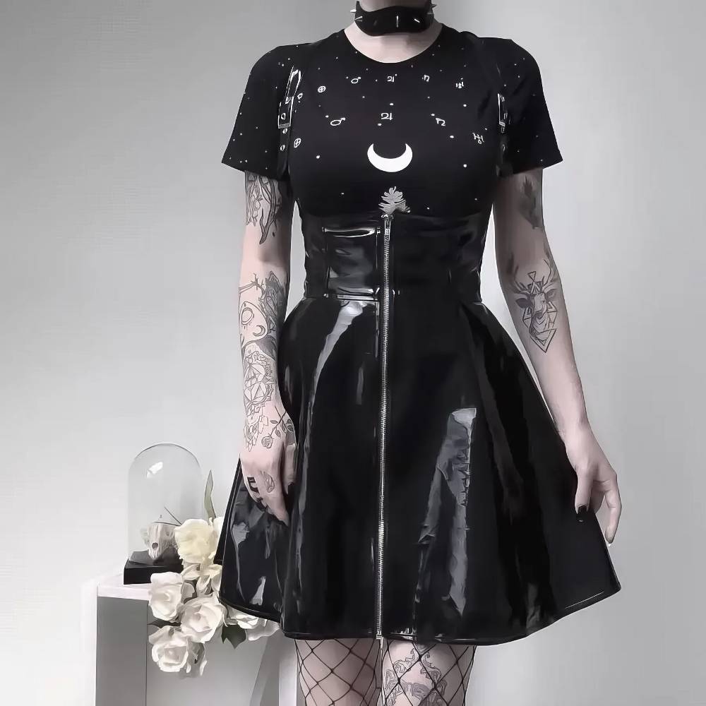 Jupe gothique cuir noir Mourningia brillante avec fermeture éclair centrale portée avec t-shirt noir à motif lune blanche