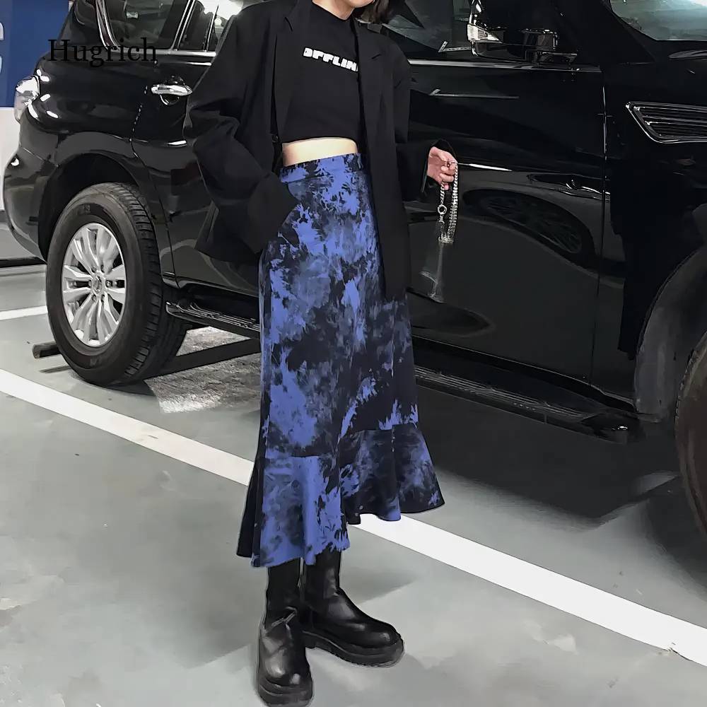 Jupe gothique noir et bleu Ebonflameia mi-longue avec motif tacheté bleu et noir, coupe évasée avec volant en bas, portée avec bottes noires épaisses