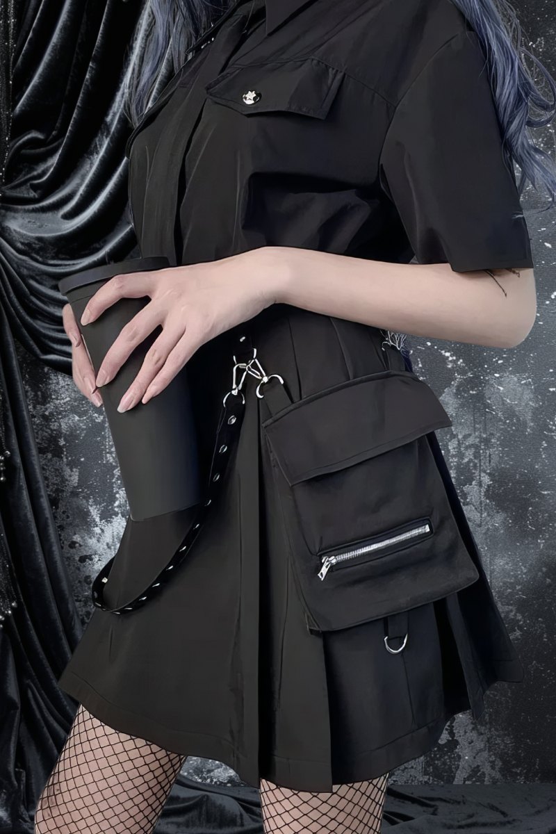 Jupe gothique noire courte Sablemistia avec poche zippée et détails en anneaux métalliques portée avec chemise noire et collants résille