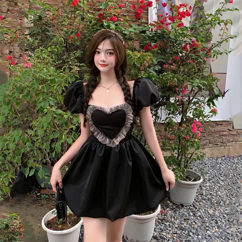 Robe gothique romantique courte noire avec corsage en cœur et dentelle beige, manches bouffantes, modèle RebelRequiem, vue de face en extérieur
