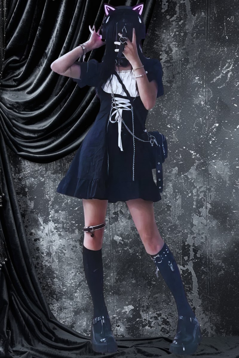 Robe style japonais gothique noire en coton avec laçage blanc sur le devant, portée avec chaussettes hautes noires et chaussures plateformes, décorée de poches latérales et d'un motif blanc sur la poitrine