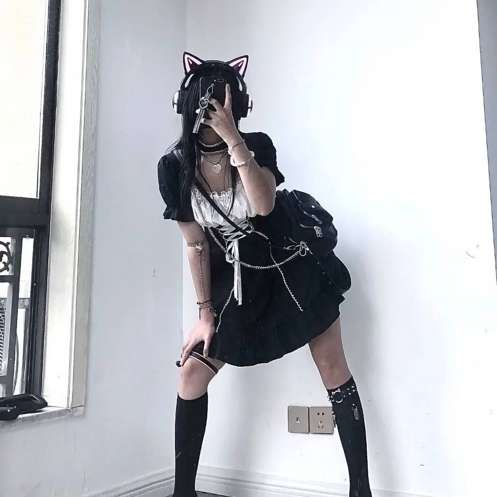 Robe style japonais gothique GothicGale noire avec jupe courte plissée, manches bouffantes et ceinture à nouer, portée avec chaussettes hautes et accessoires noirs