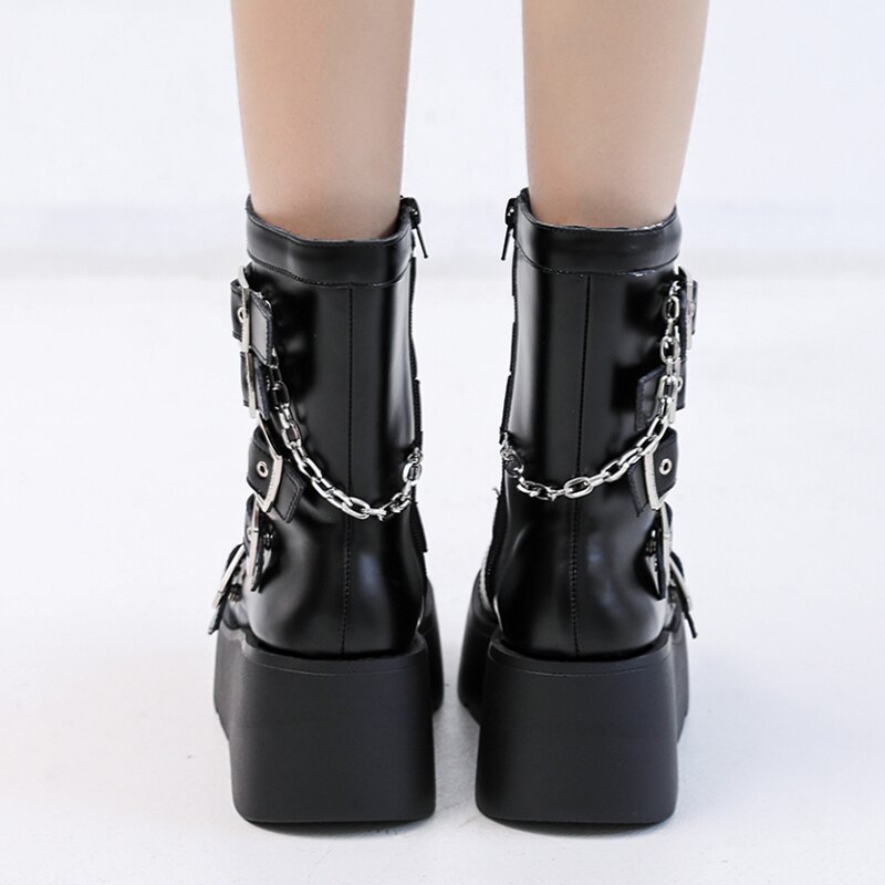 Bottes gothiques noires en cuir avec chaînes argentées et boucles, vue arrière sur plateforme épaisse