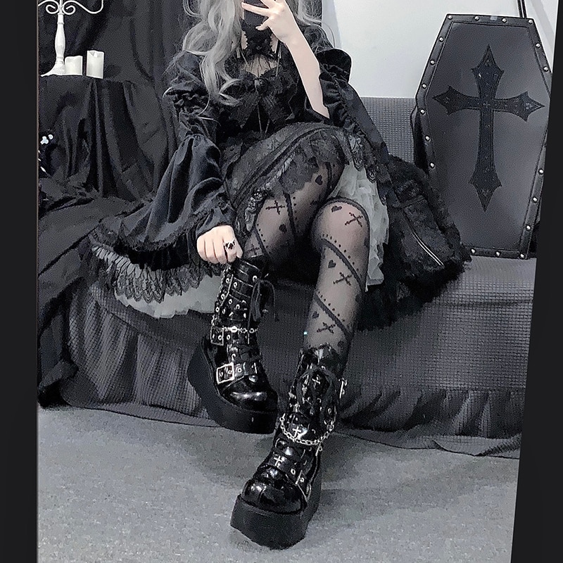 Bottes gothiques noires en cuir verni avec croix et piques, vue avant portée avec détails de boucles métalliques, style gothique chic