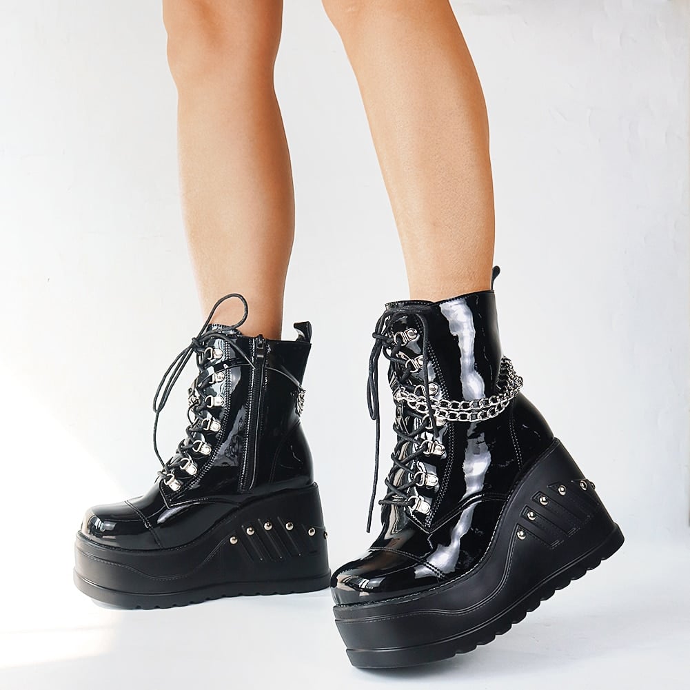 Bottes gothiques noires brillantes en cuir verni avec plateforme épaisse, lacets et chaîne argentée décorative sur le côté