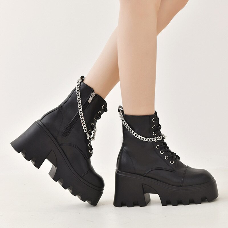 Chaussures gothiques noires en cuir avec ouverture latérale et chaîne argentée, semelle épaisse plateforme crantée, vue de profil