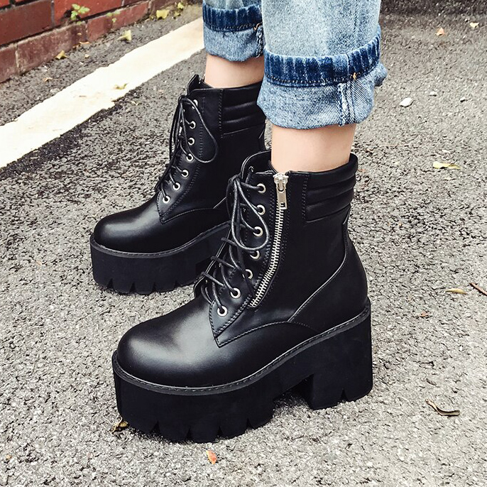 Chaussures gothiques noires en cuir avec plateforme épaisse, lacets et fermeture éclair latérale, portées avec un jean retroussé