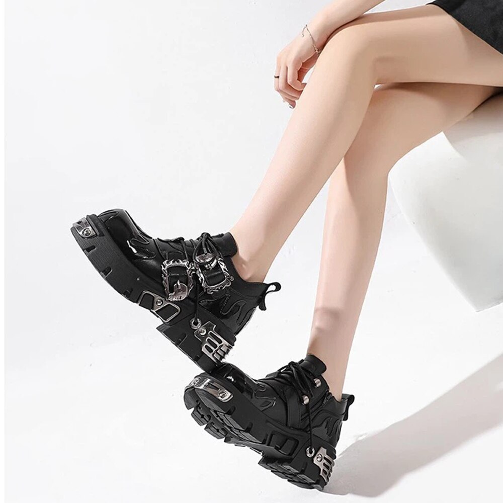 Chaussures gothiques rock noires en cuir avec boucles métalliques et semelle épaisse, vue latérale sur pieds féminins