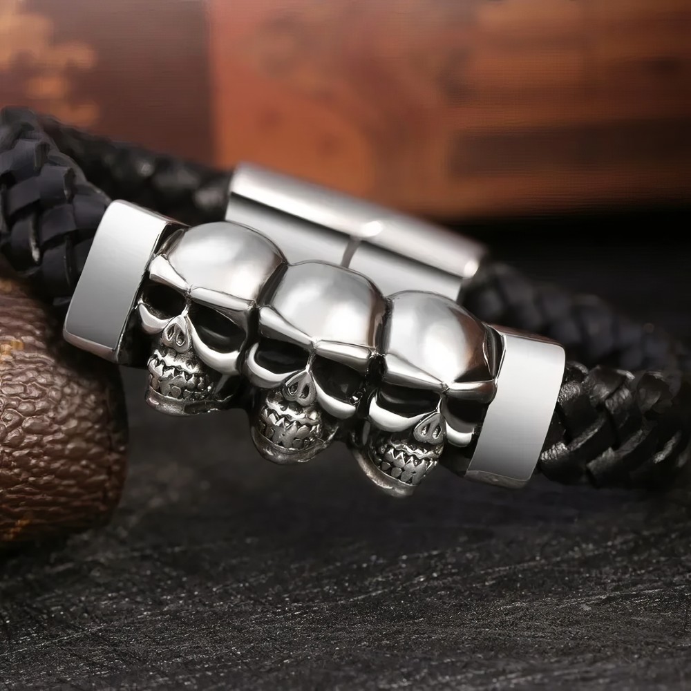 Bracelet gothique triple tête de mort en acier inoxydable avec bracelet en cuir noir tressé, détail sur les trois crânes métalliques brillants