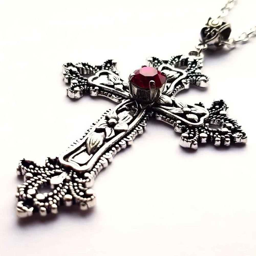 Collier Croix Gothique en métal argenté avec pierre rouge facettée au centre, détail du pendentif orné de motifs baroques et gothiques