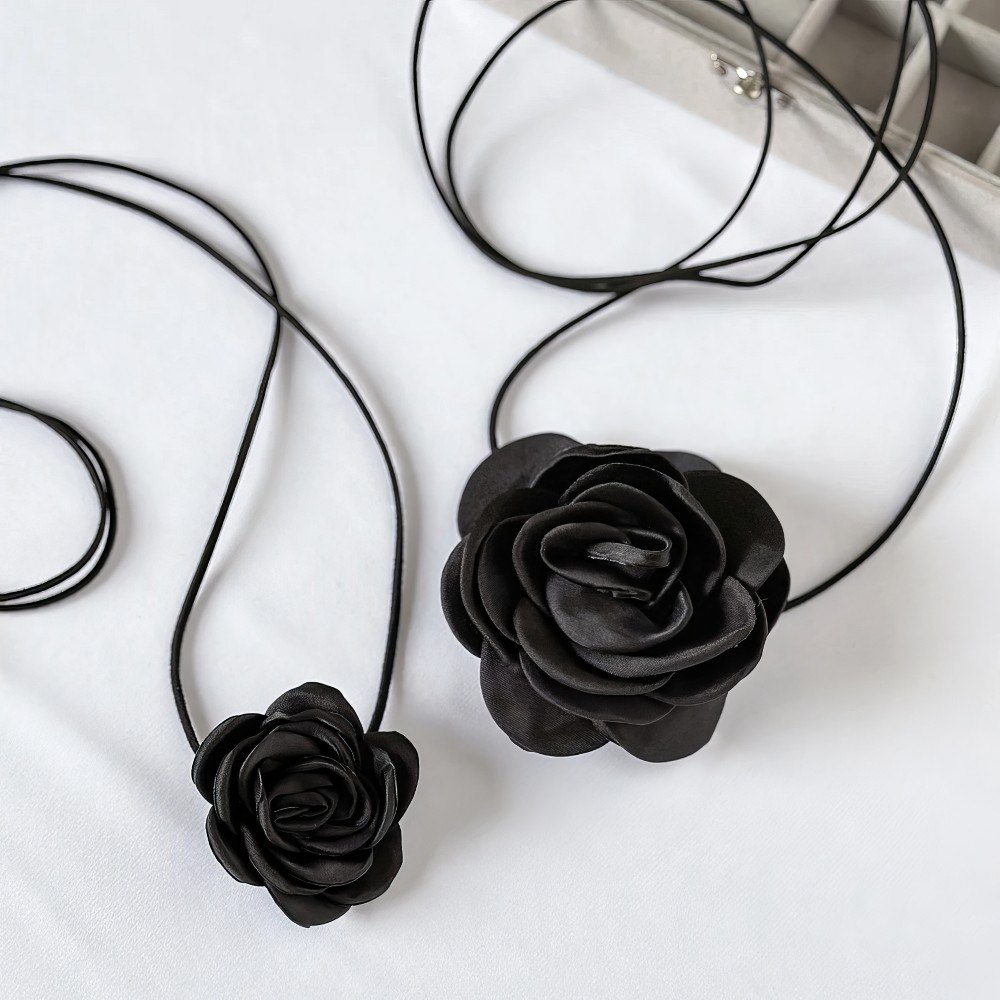 Collier Fleur Noire BlackNeck avec pendentif fleur noire en gros plan sur fond blanc, détail du motif floral en résine noire