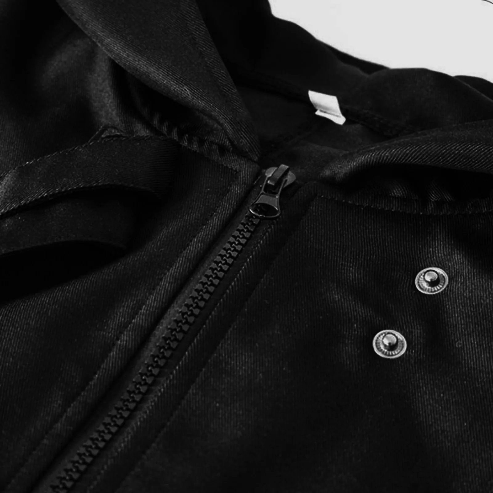 Détail fermeture éclair et boutons pression du manteau gothique long homme Nightshade en velours noir