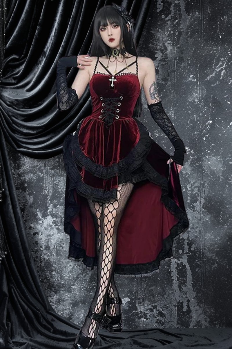 Robe gothique asymétrique rouge et noire en velours avec corset lacé et jupe à volants, portée avec gants longs en dentelle noire et collants résille