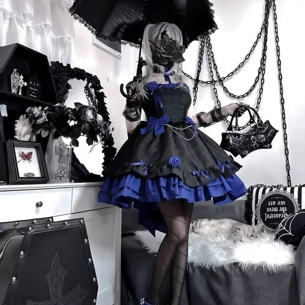 Robe gothique bleu TwilightBlue en tissu satiné avec jupe à volants et détails en dentelle noire, vue de face dans un décor gothique avec accessoires occultes