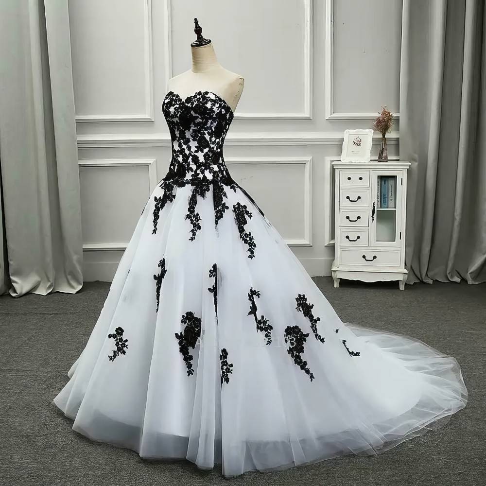 Robe gothique de mariée blanche et noire NightlyNebula avec bustier asymétrique et motifs en dentelle noire sur jupe volumineuse en tulle blanc