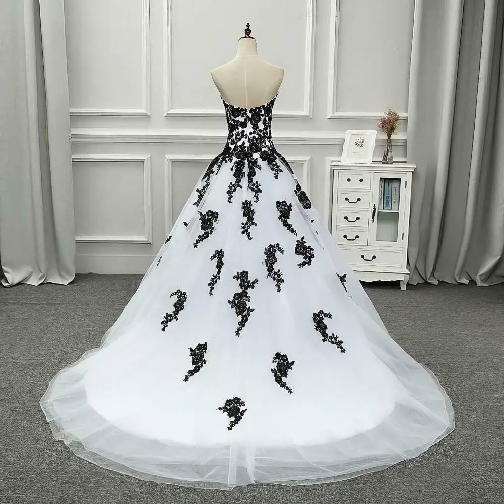 Robe gothique de mariée blanche et noire NightlyNebula vue de dos avec bustier noir orné de dentelle noire et jupe blanche à motifs floraux noirs